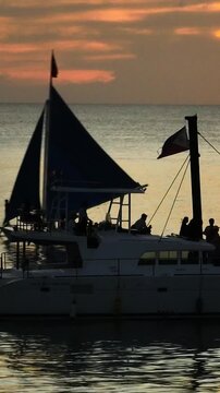 Captivating Sunset and sky over tourist boats in Boracay, Philippines. Vertical view.