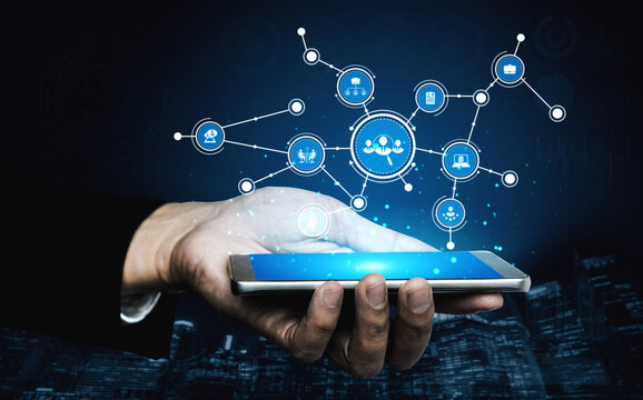 A person holds a smartphone displaying a digital network with various icons symbolizing communication, data sharing, and technological innovation in a sleek urban setting. Tessel - Powered by Adobe