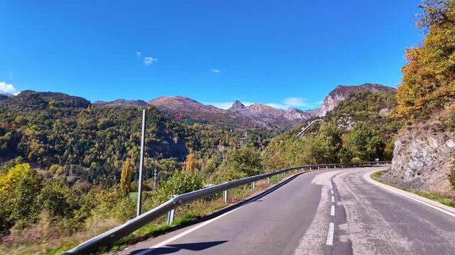 Driving through the landscape between Ainsa and Broto, showing dramatic cliffs, dense forests, and misty peaks of Ordesa Valley in the Pyrenees, Aragon, Spain.