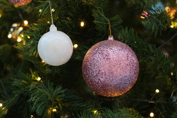 Christmas tree decorated with white and pink ornaments and twinkling lights