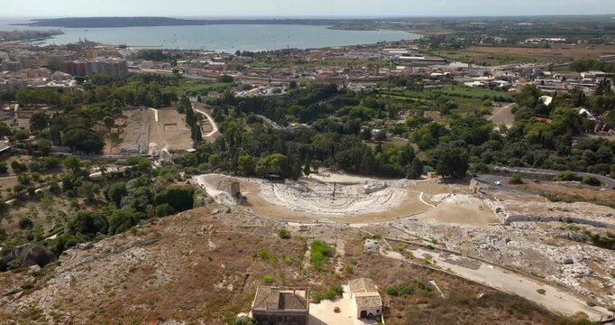 Panoramic aerial view of the Neapolis Archaeological Park, located in Syracuse, Sicily, Italy. In the background there's the modern city overlooking the gulf of the same name and the island of Ortygia