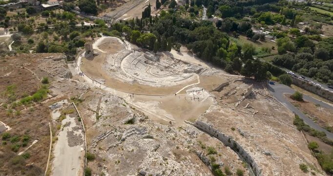 Aerial view of the Greek Theater of Syracuse, Italy. It is a Greek amphitheater located within the Neapolis Archaeological Park in Sicily. It's an attraction of the ancient colony, visited by tourists