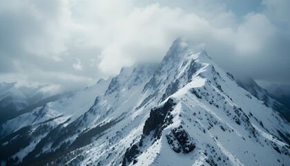 Majestic snowcovered mountain peak shrouded in dramatic, cloudy weather