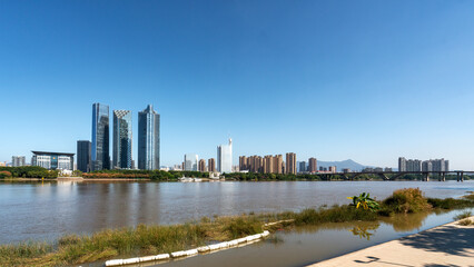 City skyline with river and modern buildings under clear blue sky