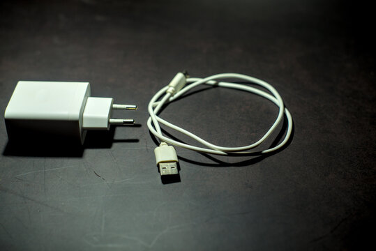 White smartphone charger on dark background. - Powered by Adobe