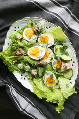 Cod liver salad with boiled eggs, cucumber, onions, lettuce