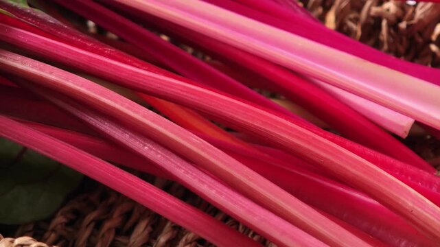 Swiss chard with bright red and orange stalks and green leaves in basket