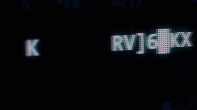 Dark digital screen with cryptic alphanumeric characters and coded visual elements.