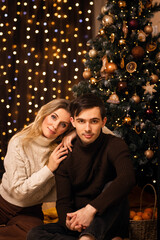 happy mother with son against the background of christmas tree and new year bokeh with sparklers