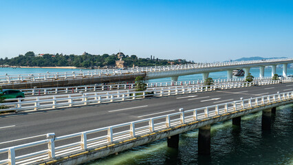 Obraz premium Scenic bridge over water with clear blue sky and distant land