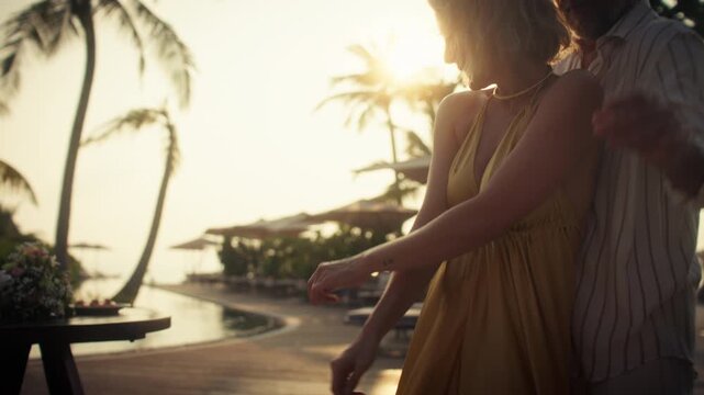 Happy couple dancing and laughing on a tropical beach at sunset