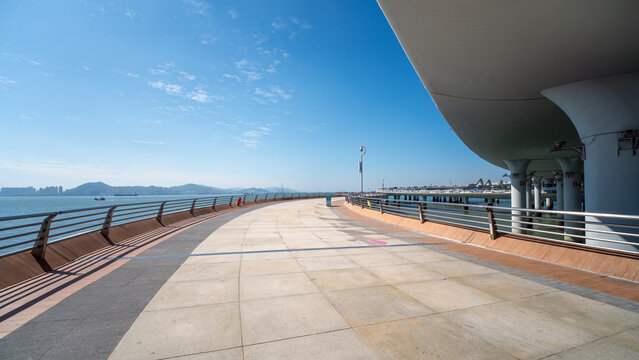 A scenic seaside walkway with clear blue sky and calm sea