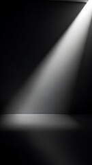 A single spotlight shines a bright beam of light into a dark, empty room, illuminating the floor.