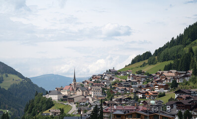 Santa Cristina Gherd&euml;ina, Italy - 21 July 2025: Panoramic view of village in Val Gardena, Italian Dolomites mountain range in South Tyrol, with church tower rising over the town in summer