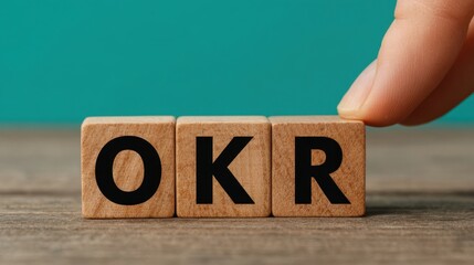 Optimizing okr management hand arranging wooden blocks with letters in a cozy office environment