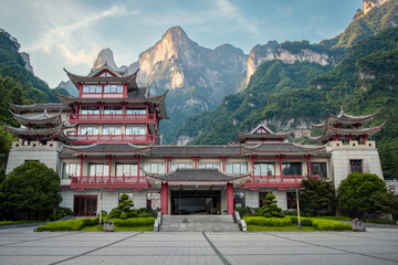 Wooden chinese style architecture builing at the entrance to Tianmen Mountain with a mountain in the background. Photo taken in Zhangjiajie Hunan