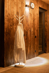 Modern coat rack with towel in warm wooden interior space