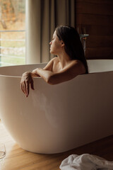 Relaxing in a modern bathtub with wine and scenic view outside