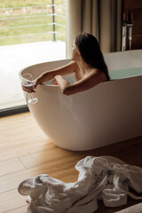 Relaxing in a modern bathtub with wine and scenic view outside