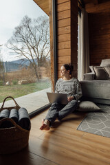 Cozy work space with a woman using a laptop by the window