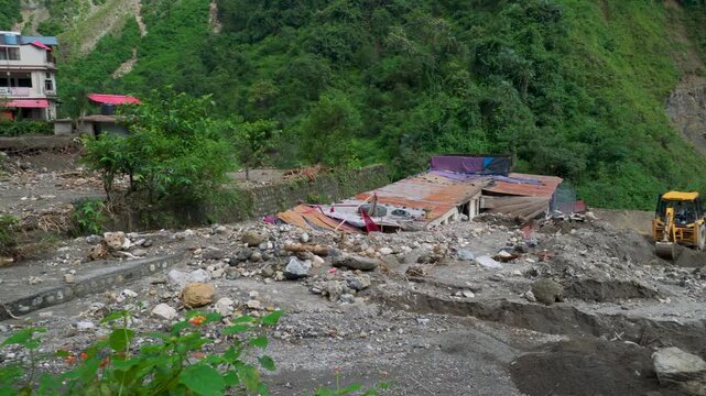 Earthmovers clear debris in Sahastradhara Dehradun after Badli river flash flood