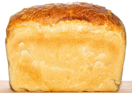 Bread loaf is displayed on a wooden cutting board, fresh, homemade appearance. Freshly baked bread on wooden cutting board isolated on white background
