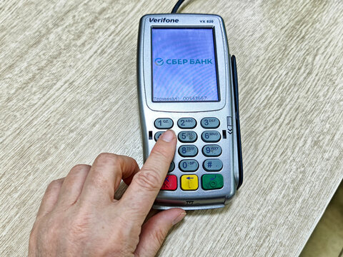 Kirov, Russia - August 26, 2025: Person using payment terminal at a transaction point in a modern retail environment