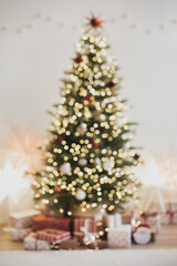 Defocused magic christmas interior with christmas tree, stars, gifts and decoration, Winter holiday xmas home decor blurred background.