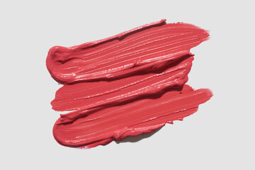 Lipstick or creamy blusher abstract strokes smudges  background texture multi colored coral blush isolated on neutral grey background