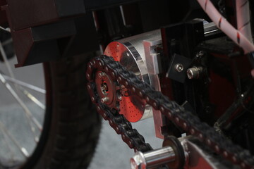 DC motor connected to wheels of the bike through the chain system. Working model of electric bike with a view of its motor