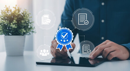 Hands using a digital tablet with quality assurance graphics showcasing certification and compliance with standards for business excellence and customer satisfaction in a modern office setting