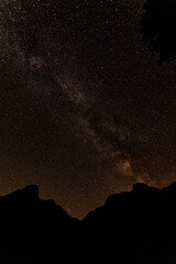 Milky Way over Mountain Silhouettes - Starry Night Sky and Galactic Core Above Dark Peaks