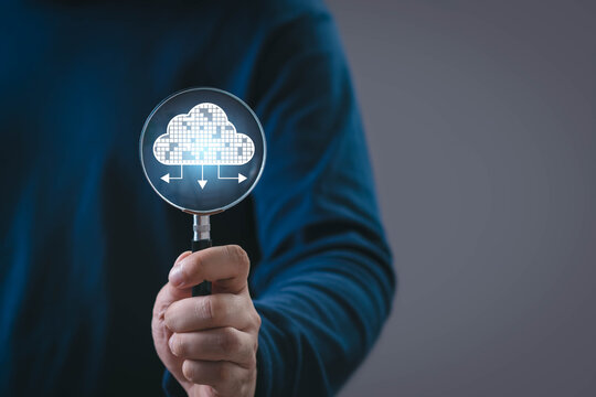 A person holding a magnifying glass showing a digital cloud icon with data flow arrows, representing cloud computing, data analysis, cybersecurity, storage management, and modern technology solutions.