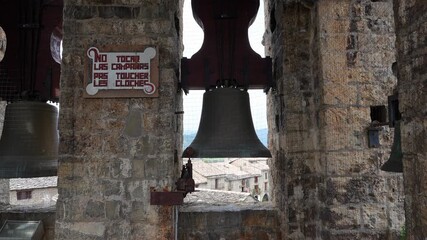 The bells are ringing in the stone bell tower of the romanesque Holy Mary Church, Iglesia de Santa Maria in Ainsa, a small rural village in the Spanish Aragonese Pyrenees mountains in Spain