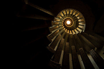 Golden-lit Spiral Staircase Inside Manoir Colimacon - Dramatic Vertical View of an Abandoned Rotunda