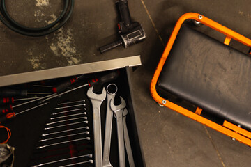 Close-up of mechanic workshop tools: wrenches, hammer, and measuring tape on a workbench. Maintenance and repair concept.
