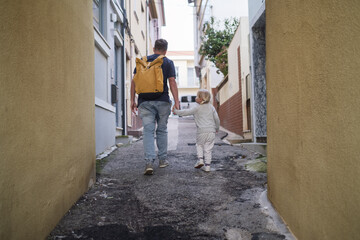 Girl walking with father in narrow streets of Portugal