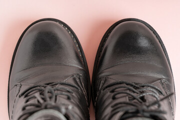 Top close up view of pair of dress woman shoes or boots made of black shiny leather with laces on a...
