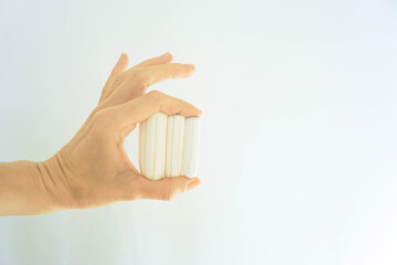 Woman's hands displaying organic tampons on a neutral backdrop. Represents modern menstruation solutions, eco-conscious period choices, body-positive cycle care, and toxin-free feminine hygiene.