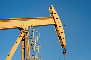 Beam pump or Donkey pump operating to recovered crude oil from the production oil well, with sunny...