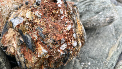 Close-up of rough mineral rock formation with varied texture and colors