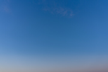 Clear blue sky with light clouds and gradient horizon
