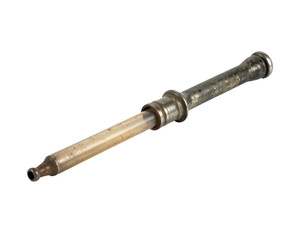 Vintage metal syringe with glass barrel medical instrument showing patina and wear on isolated background
