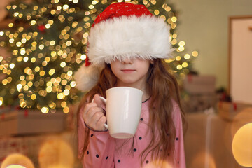 Little girl is holding a mug with hot drink. Merry Christmas