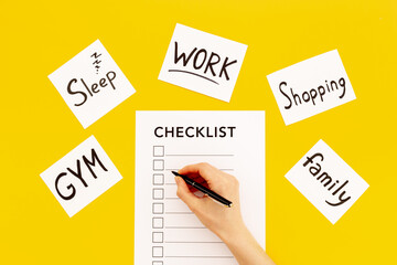 Hand writes in Checklist and many paper cards with hand drawing of different life activities, top view. Life balance and planning concept.