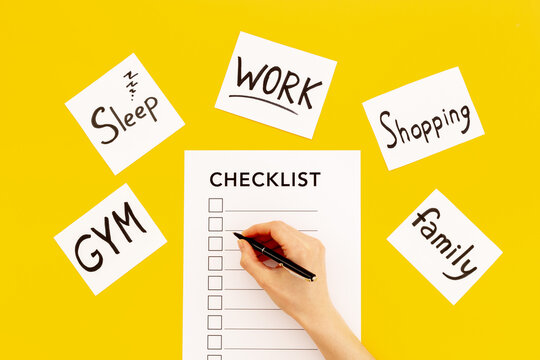 Hand writes in Checklist and many paper cards with hand drawing of different life activities, top view. Life balance and planning concept.