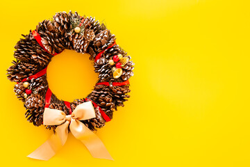 Christmas wreath made of tree bark and dry cones on the wall. New Year DIY decoration