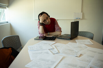 Stressed Male Professor With Headache From Grading, Male Educator Resting Hand on Forehead in Despair