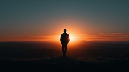 Sunset view from a mountain with a silhouette of a person standing alone