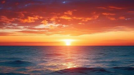 Obraz premium A breathtaking sunset over a tranquil ocean, with vibrant hues of orange and blue reflecting on the water's surface.